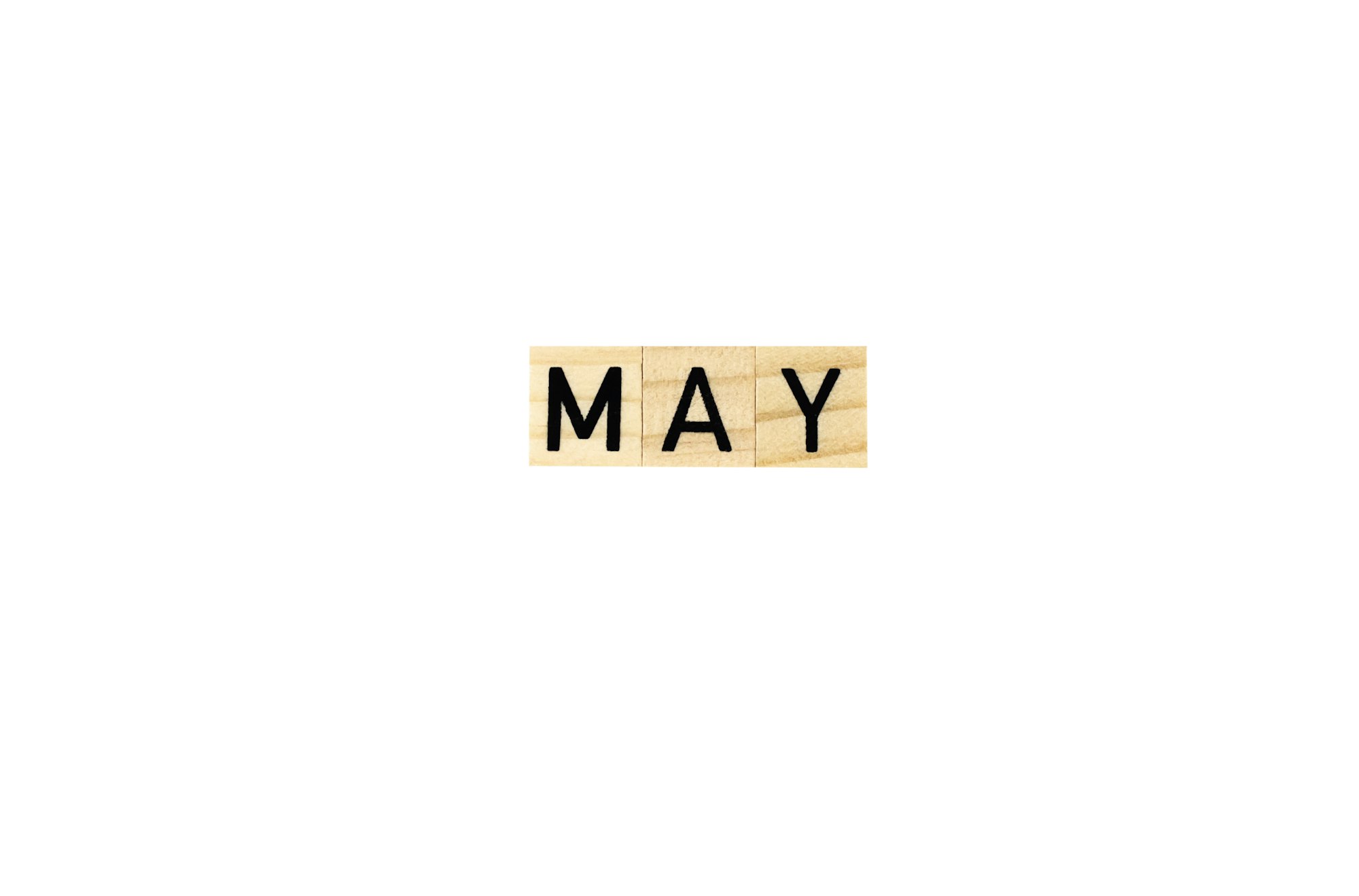 The word may in wooden letters on a white background.